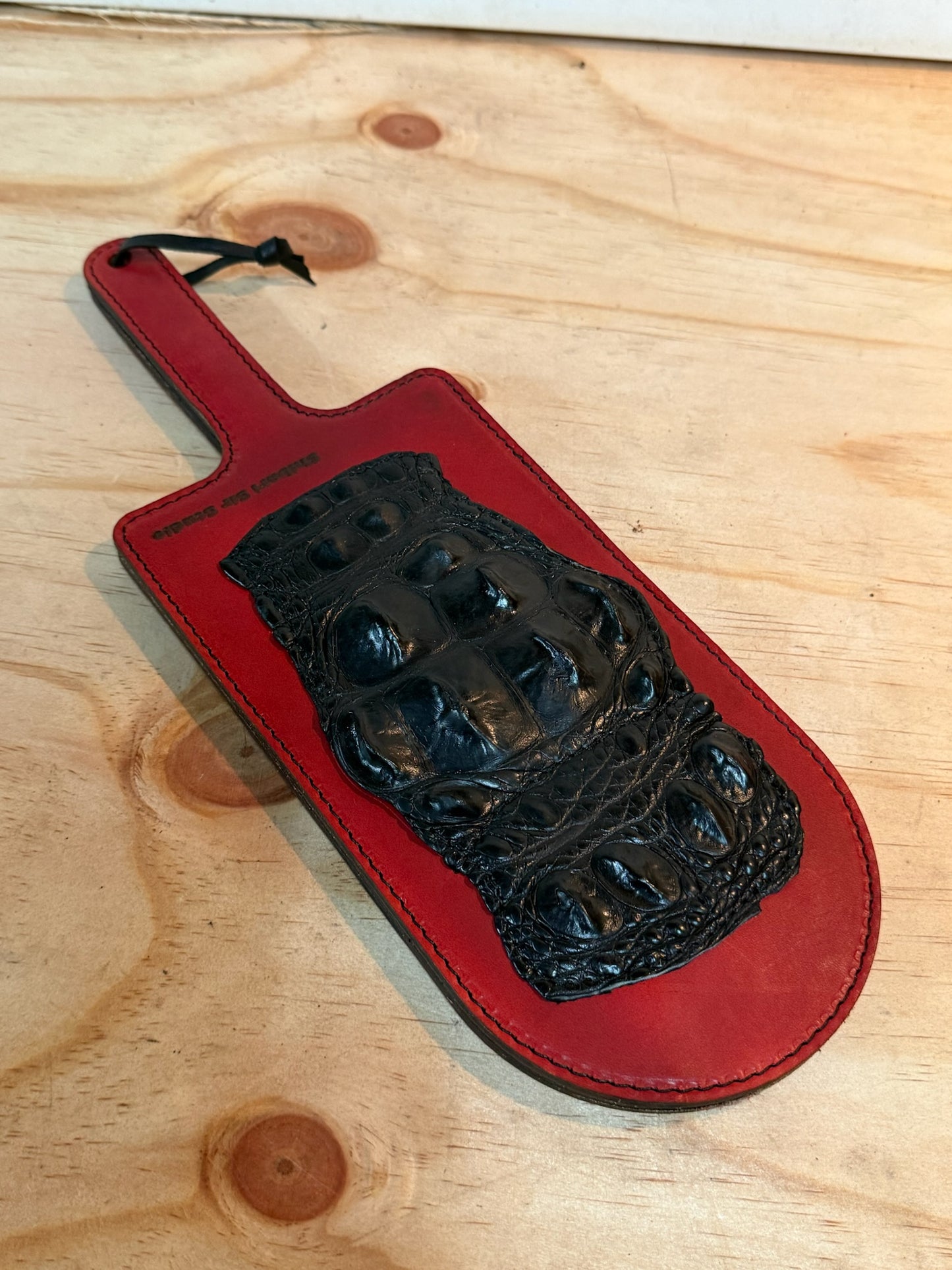 Red paddle with black crocodile